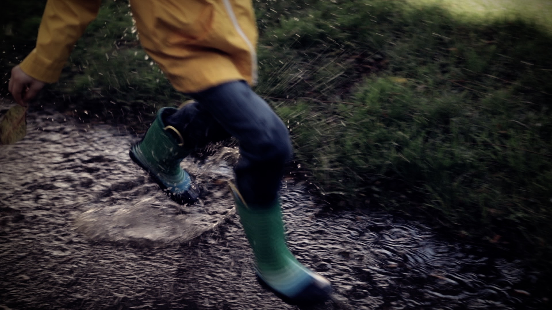 a boy splashing in puddles