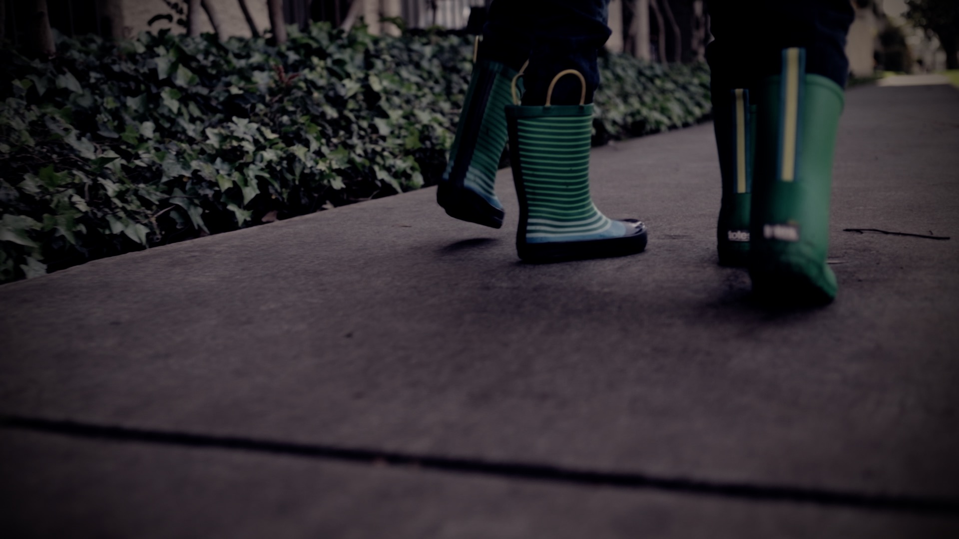 close up of feet walking with rain boots on